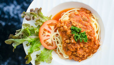 italian spaghetti topped with bolognaise, or bolognese, sauce with tomatoes.の写真素材