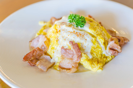omelet and bacon on white plateの写真素材