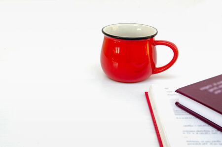 red cup of coffee and two books on white backgroundの写真素材