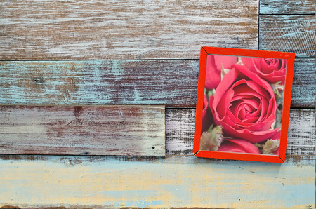 Red rose in wooden frame hanging on a wooden board, Valentine's day conceptの写真素材