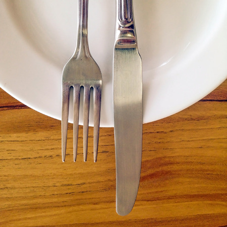 Knife and fork on white dishの写真素材