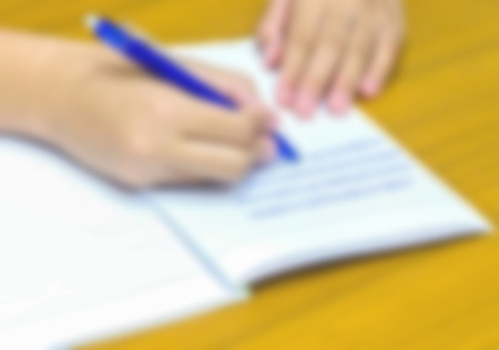 Defocused and blur image of  hand write on the bookの写真素材