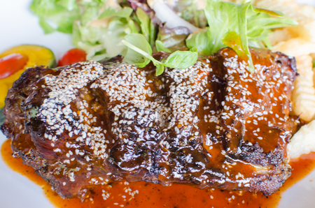 rib steak with vegetables on white plate.の写真素材