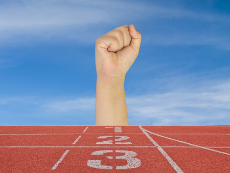 hand fist with running track number standard red color under the blue sky.の写真素材