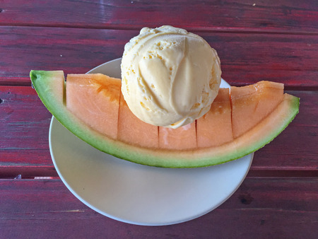 Vanilla Ice cream scoop on melon slide.の写真素材