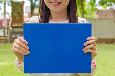 smiling beautiful young girl holding a  communication boardの写真素材