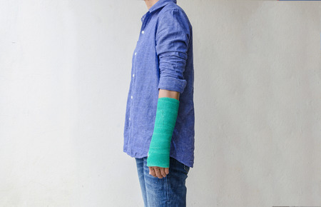 Injured woman with green cast on hand and arm, Travel insurance concept.の写真素材