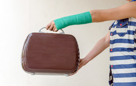 Injured woman with green cast on hand and arm, Travel insurance concept.