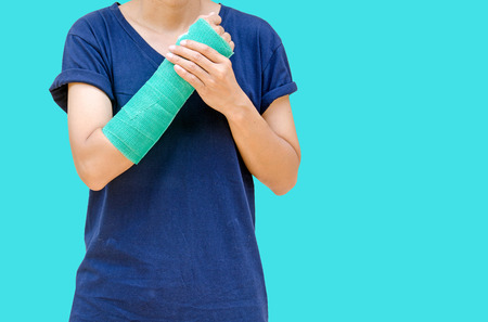 Green cast on hand and arm isolated on blue background.