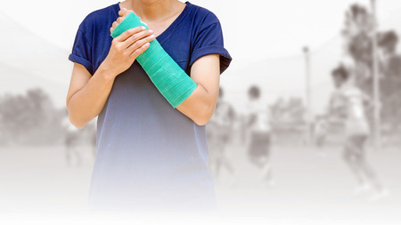 broken arm with green cast on blurred background kid soccer player in academy.の写真素材