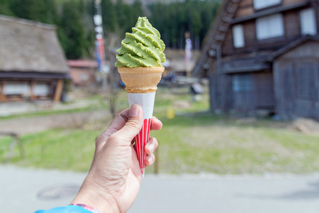 Hand holding green tea ice cream in Japan.の写真素材