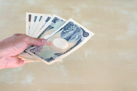 hand woman with Japanese currency yen bank notes.