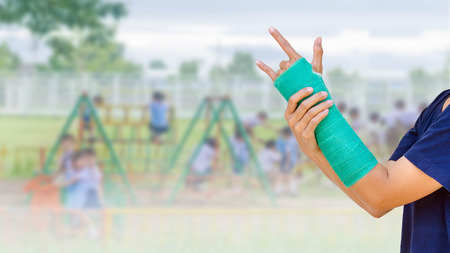 green cast on hand and arm on blurred background student playing with toy on playground in the...