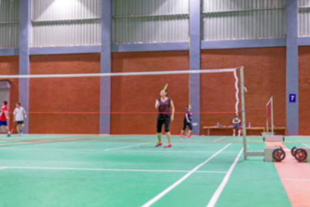 badminton court with blurred woman players playing badmintonの写真素材