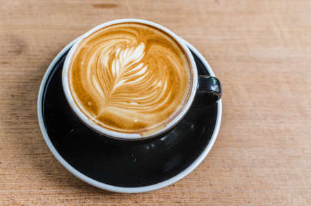coffee latte art on wood table in cafe, selective focus top view.の写真素材