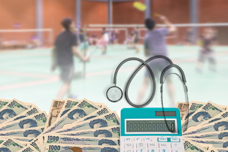 Health care cost, Top view stethoscope with calculator, Japanese currency yen bank notes and Japanese coin on blurred background badminton player in court.の写真素材