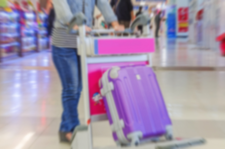 motion blurred travelers walking with a luggage at airport terminal, travel and adventure conceptの写真素材