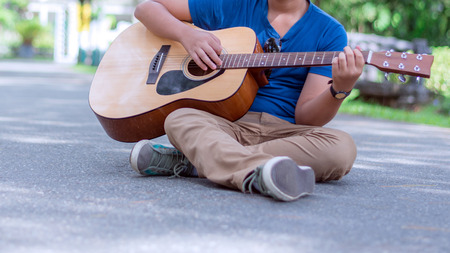 teenager playing the guitar in nature park.の写真素材