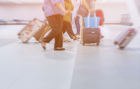 motion blurred group of travelers walking with a luggage at airport terminal, travel and adventure concept.の写真素材