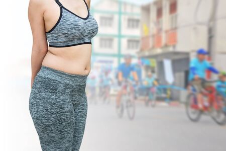 woman with belly fat wearing sportswear isolated on blurred background woman riding a bicycle, clipping path included.の写真素材
