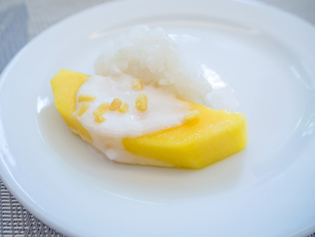 sweet mango with sticky rice with coconut milk on white plate.の写真素材