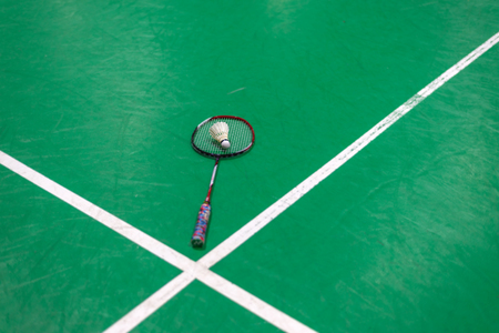 badminton shuttlecock and racket on green court.の写真素材