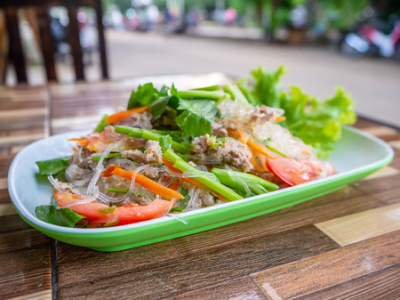 Thai spicy vermicelli salad with minced pork in a white plate.の写真素材