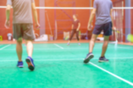 blurred background badminton player on green court.の写真素材