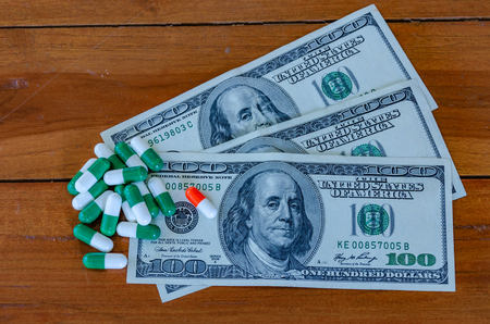 american hundred dollar bills with capsules on wood, vintage tone.の写真素材