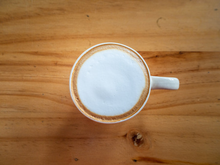 cup of cappuccino with latte art on wood background.の写真素材
