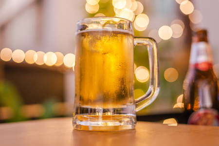 cold beer glass on a bar scene in the background.の写真素材