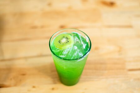 Italian Soda Cold Beverage and Kiwi Fruit on top in cafeの写真素材