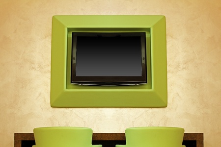Large TV screen in modern interior with green chairsの写真素材