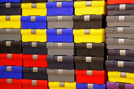 Large pile of colorful plastic closed tool boxesの写真素材