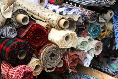 Large pile of colorful fashion patterns textile rollsの写真素材
