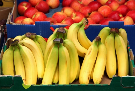 Fresh organic bananas with red apples sold on marketの写真素材