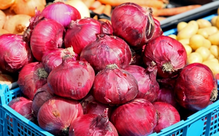 Bunch of red onions arranged for sale on marketの写真素材