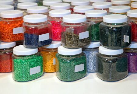 Bunch of transparent glass jars filled with colorful beadsの写真素材