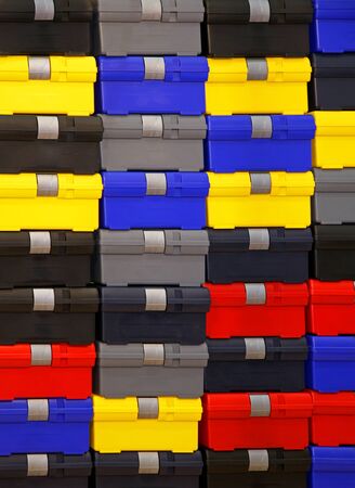Large pile of colorful plastic closed tool boxesの写真素材