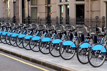 Long row of bicycles for rent parked on a streetの写真素材
