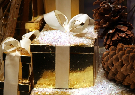 Christmas present packed in gold box with beige ribbonの写真素材