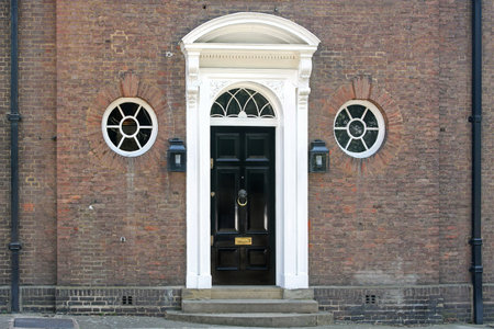 Old brick wall house with black entrance doorのeditorial素材