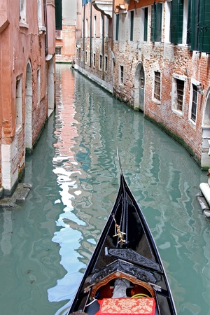 Narrow street canal in Venice with Gondola frontの写真素材