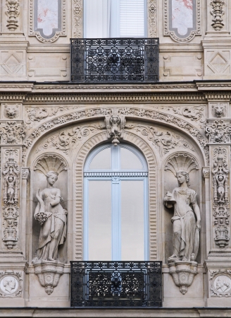 Old Paris architecture building facade with stone statuesの写真素材