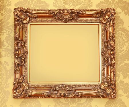 Gold Baroque frame with carved edges on beige wallの写真素材