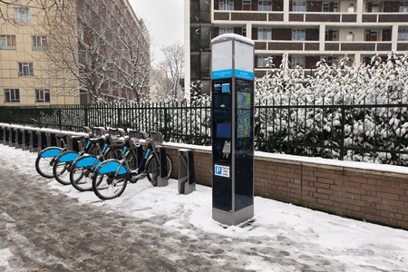Bicycles parked on street pavement covered with snowの写真素材