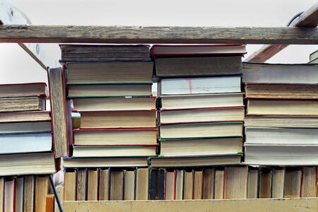 Pile of old books on wooden shelf