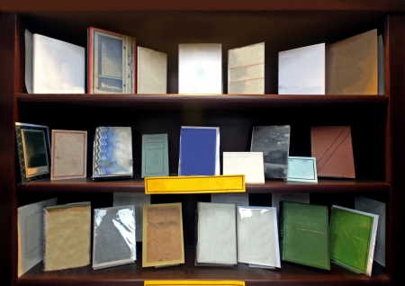 Hardcover books arranged tidy on wooden bookshelfの写真素材