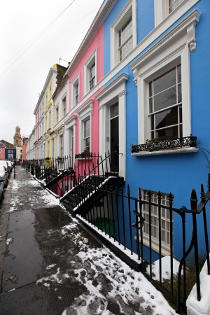 Row of residential houses on urban street during winter day under snowの写真素材