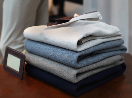 Neatly folded men sweaters on wooden shelfの写真素材
